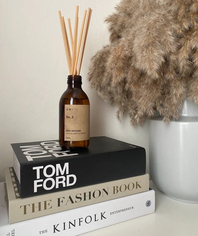 Luxurious soy wax candle with a flickering flame in a glass jar, surrounded by floral and citrus elements, offering a calming and elegant atmosphere.